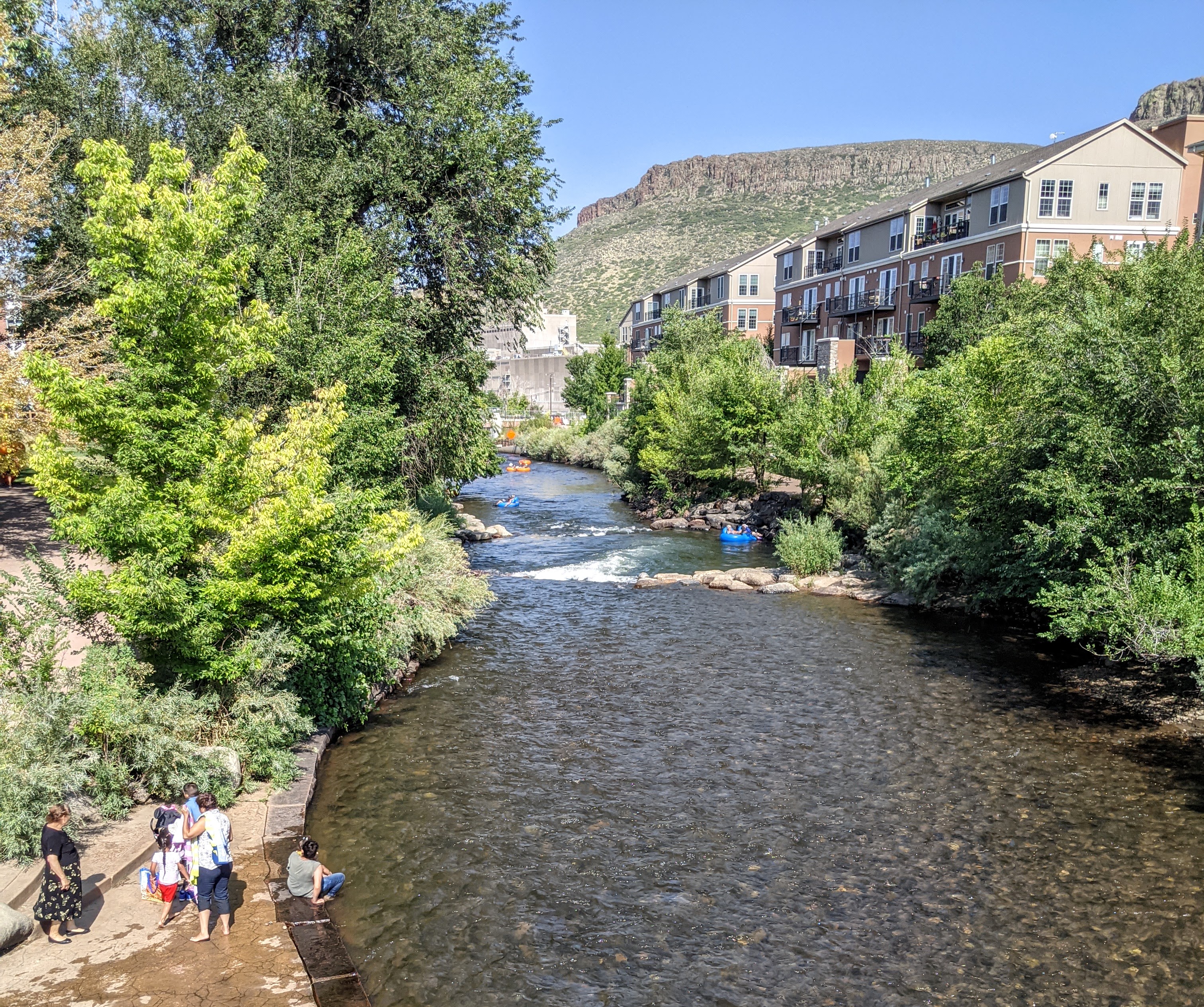 "Clear Creek Golden CO with South Table Mountain and tubers" by Dicklyon is licensed under CC BY-SA 4.0.
