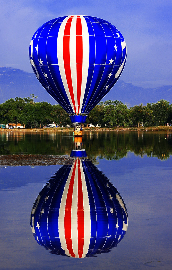 "76 Stars and Stripes, Red, White, & Blue Hot Air Balloon Dipping in Prospect Lake, Memorial Park, Colorado Balloon Classic" by Beverly & Pack is licensed under CC BY 2.0.